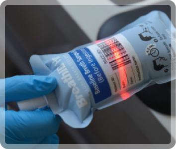 Gloved hand holding a syringe and vaccine vial, preparing an injection.