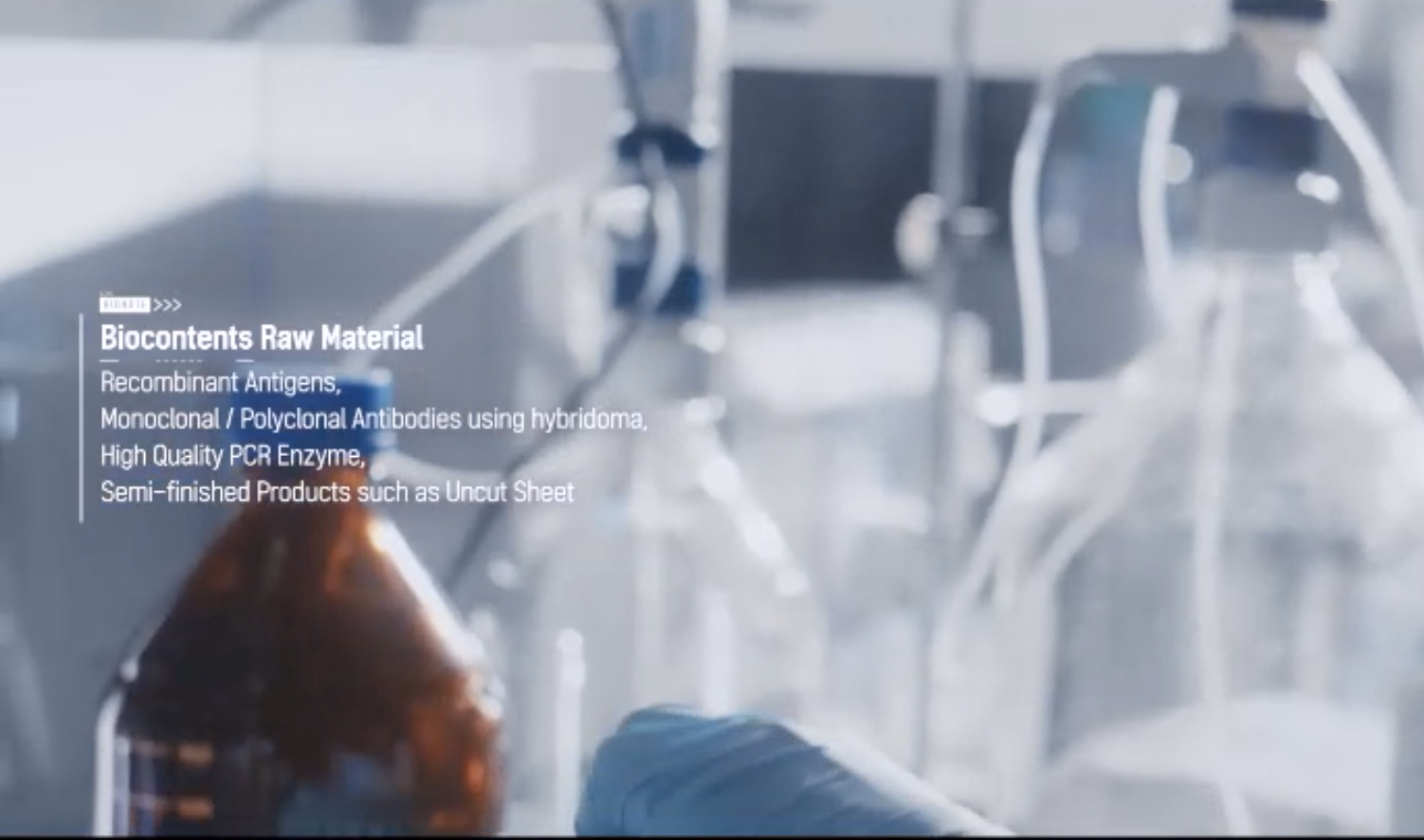 Blurry lab scene with a text overlay reading 'Biocontents Raw Material' and bullet-like lines about recombinant antigens and PCR enzymes, suggesting a lab slide title.