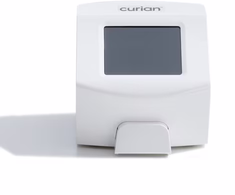 White compact medical device with a small display screen and a foot pedal at the base, branded ‘curian’ on top, suggesting hands-free operation.