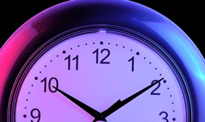 Close-up of an analog clock with a purple-tinged face and black hands under neon lighting.